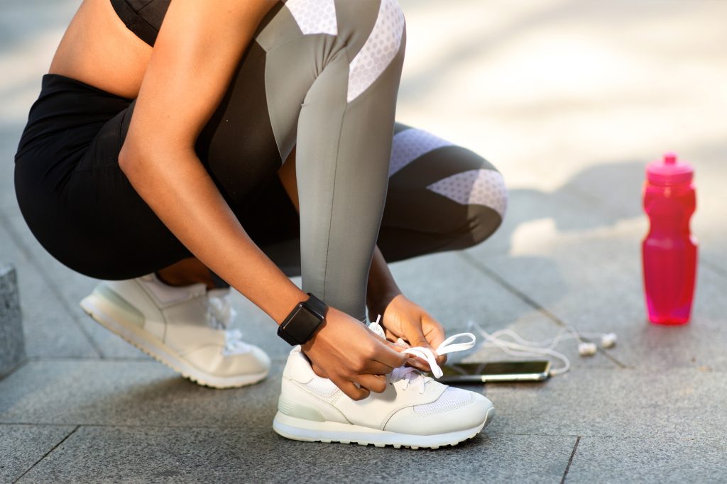 A woman tying the laces of her running sneakers